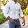 White long sleeve button-down shirt worn by a man against a blurred nature backdrop. The shirt features a slim, casual style and the man is wearing dark gray pants and a belt. The image showcases a stylish, modern men's casual clothing item from the Gifts Vip store.