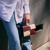 Fashionable cowhide flip chessboard handbag by Gifts Vip, held by a person wearing a white shirt and blue jeans